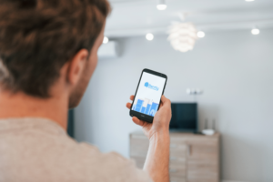 Man holding mobile device with Rently Logo on screen Man holding mobile device with Rently Logo on screen