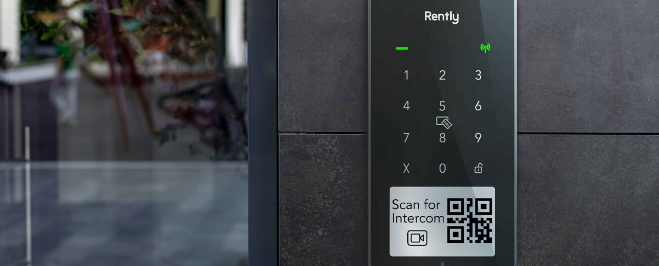 Photo of the Rently Access Panel with Intercom mounted on a wall beside a glass door