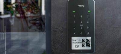 Photo of the Rently Access Panel with Intercom mounted on a wall beside a glass door