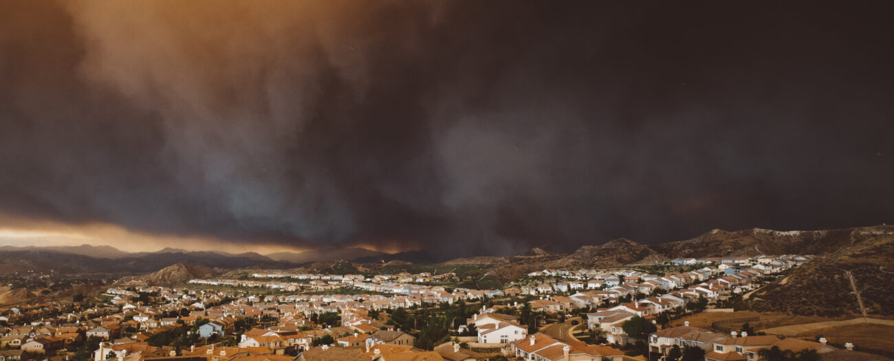 The smoke from Los Angeles wildfire Santa Clarita cityscape at sunset in California